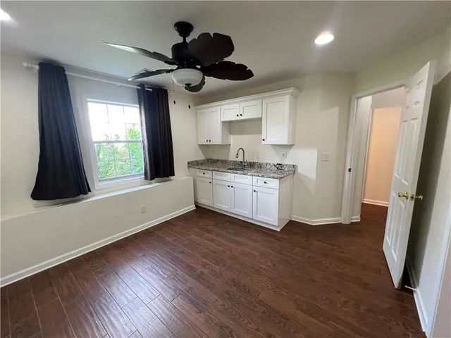 a kitchen with a stove and wooden floor