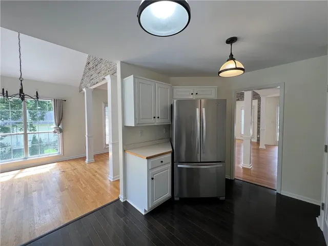 a kitchen with stainless steel appliances granite countertop a refrigerator a stove and a wooden floors