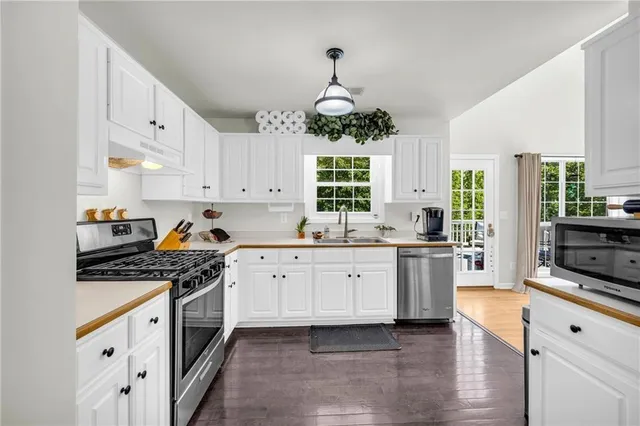 a kitchen with granite countertop stainless steel appliances a stove a sink a counter space and cabinets