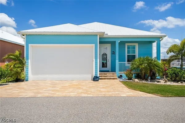 a view of a house with pool lawn chairs under an umbrella
