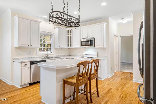 a kitchen with stainless steel appliances granite countertop a white cabinets and a stove top oven