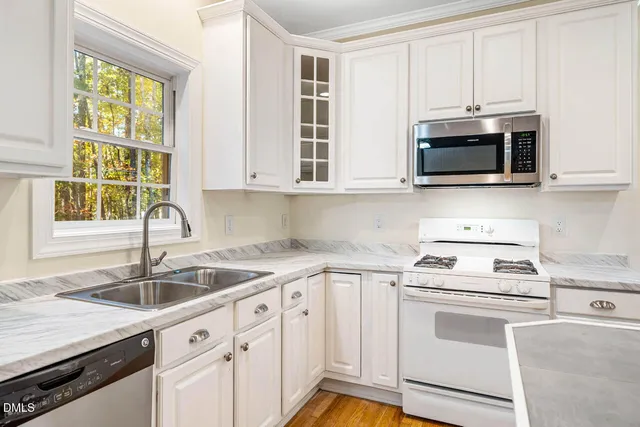 a kitchen with granite countertop white cabinets and white appliances