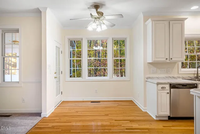 a view of an empty room with window and wooden floor