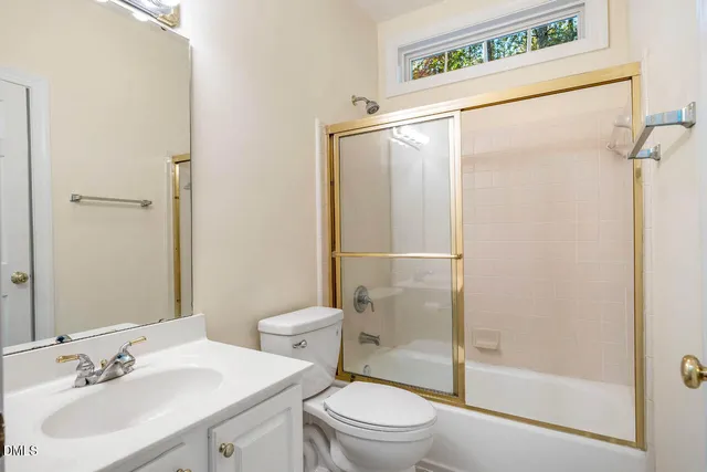 a bathroom with a sink mirror vanity and toilet