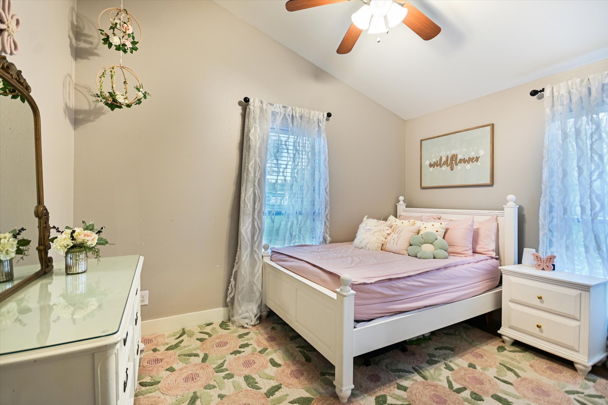 2411 Spoke Hollow Road Wimberley, TX 78676 - Photo 16 of 37 Discover a charming bedroom with vaulted ceilings and a plush floral carpet.