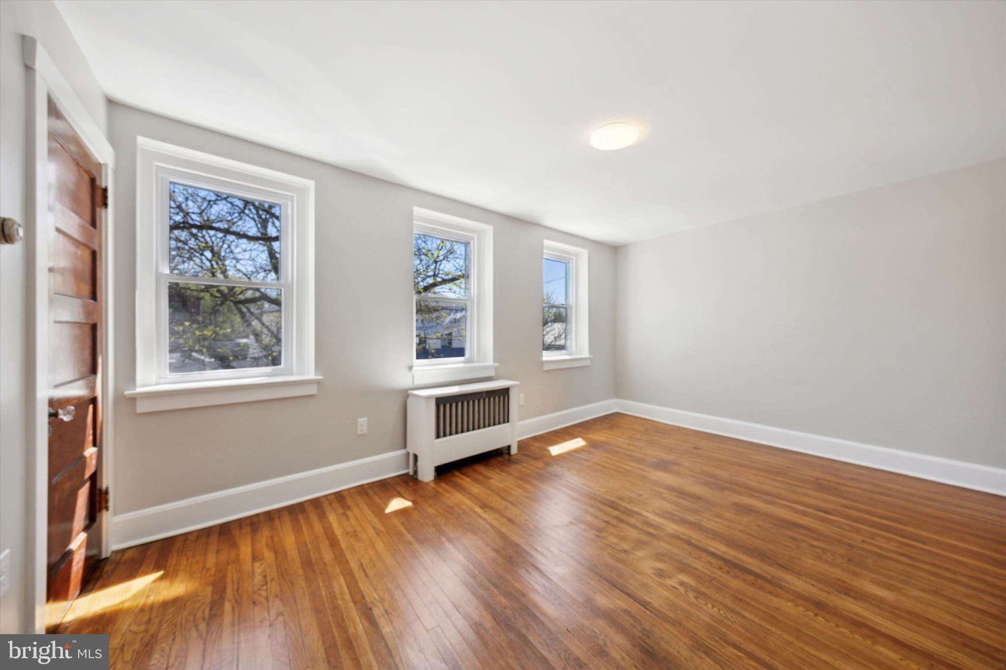 241 Haverford Avenue, Unit 3 Narberth, PA 19072 - Photo 2 of 13 an empty room with wooden floor and windows