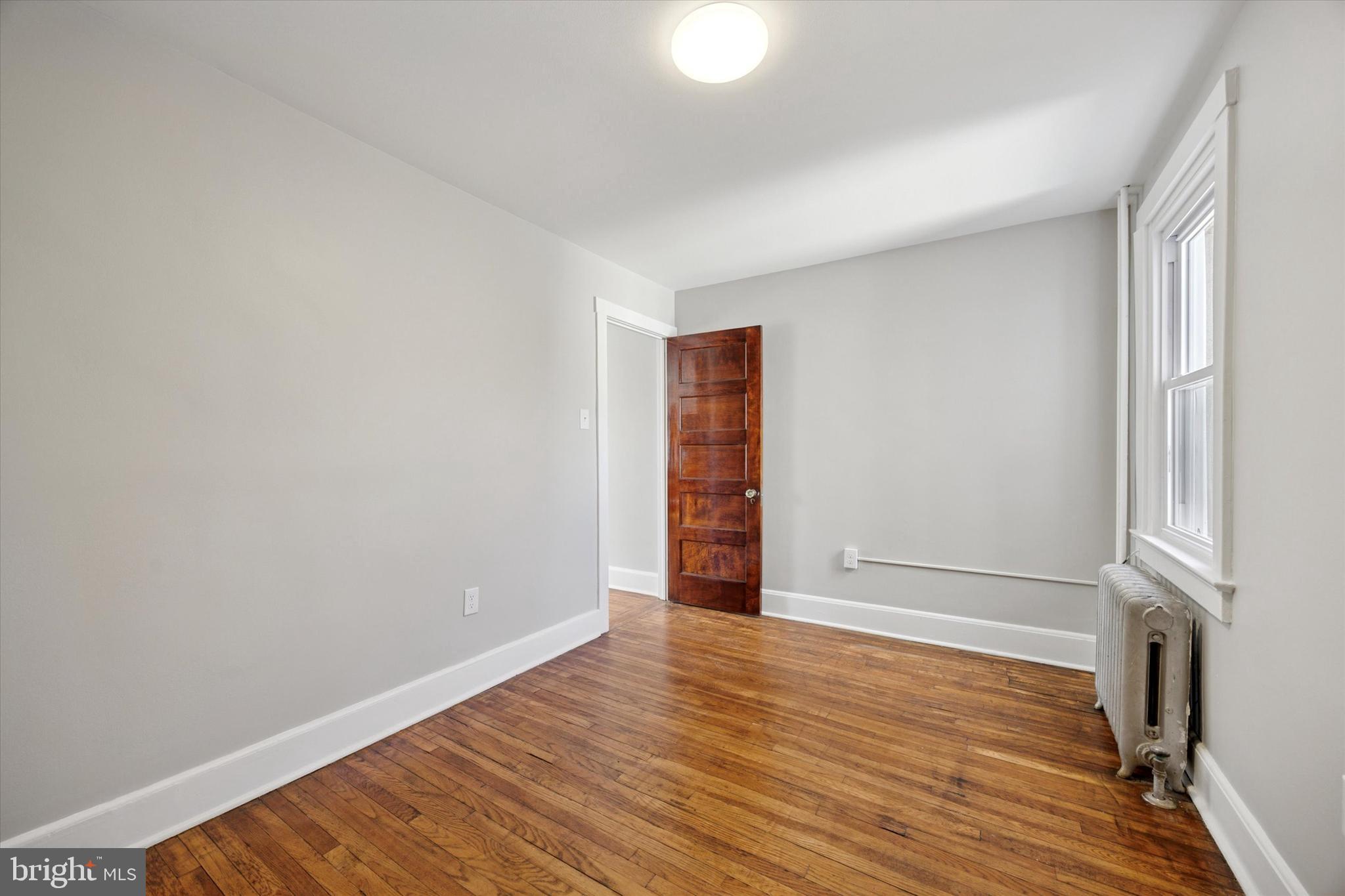 241 Haverford Avenue, Unit 3 Narberth, PA 19072 - Photo 4 of 13 a view of an empty room with wooden floor and a window