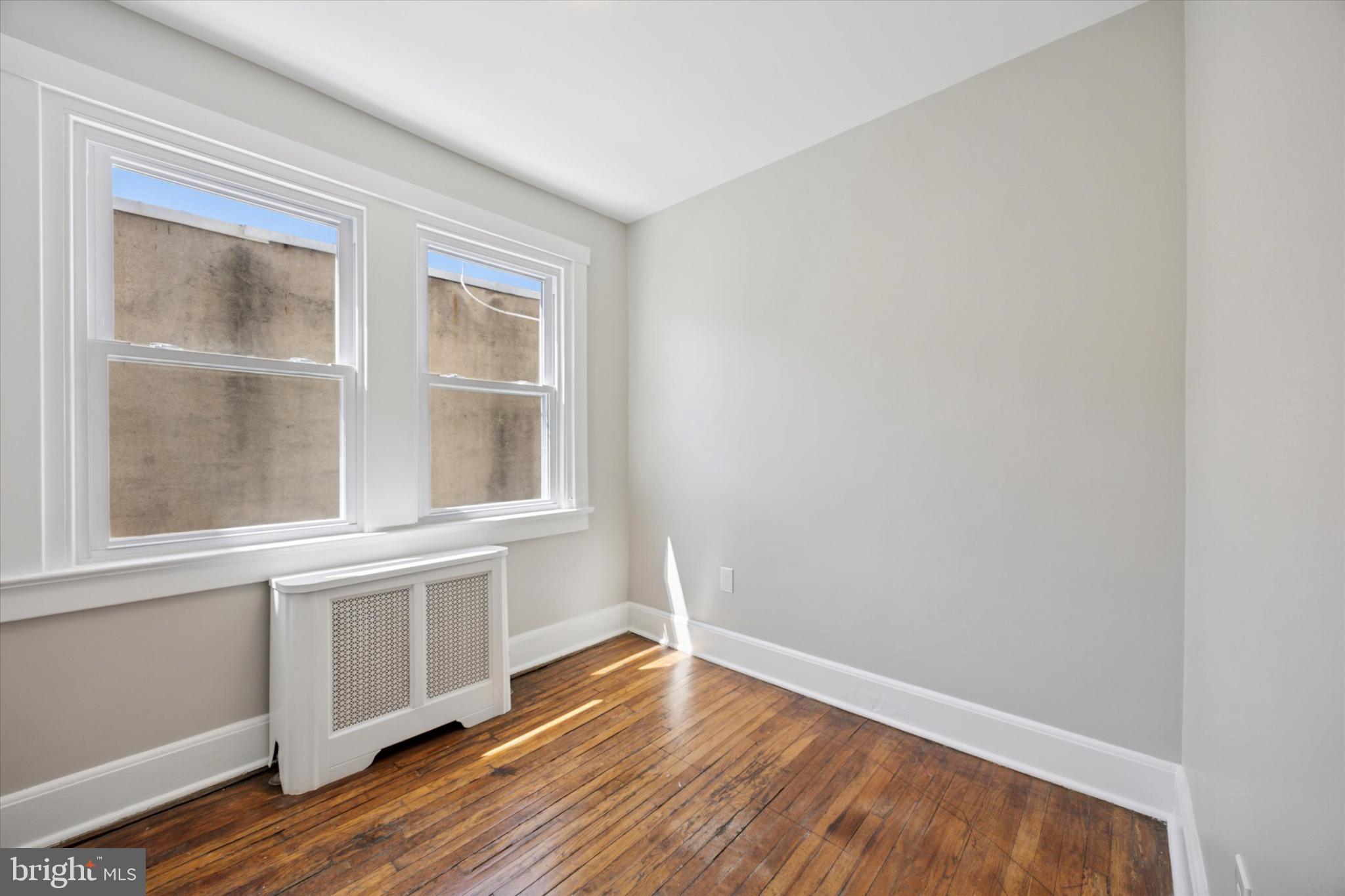 241 Haverford Avenue, Unit 3 Narberth, PA 19072 - Photo 7 of 13 a view of an empty room with wooden floor and a window