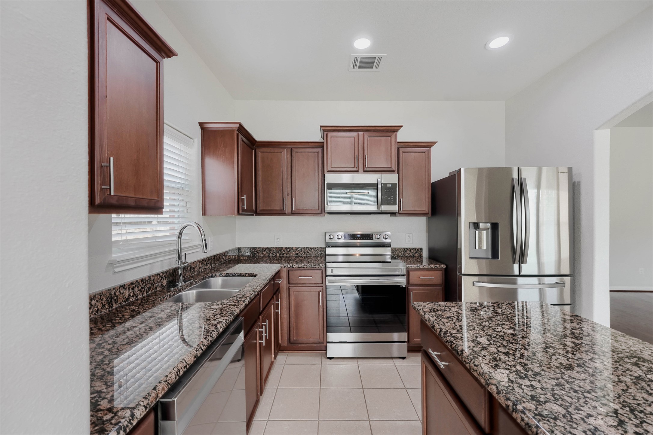 13408 Clara Martin Road Manor, TX 78653 - Photo 8 of 27 a kitchen with stainless steel appliances granite countertop a stove a sink dishwasher a refrigerator and a oven with wooden floor