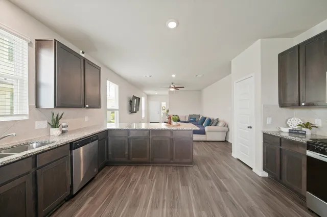a view of a hallway with wooden floor windows and a bathroom