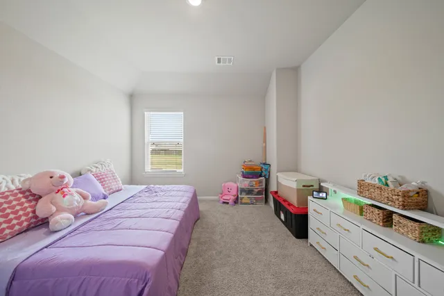 a view of a white house next to a yard with big trees