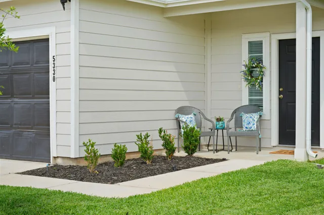 a view of a backyard with a garden and entertaining space