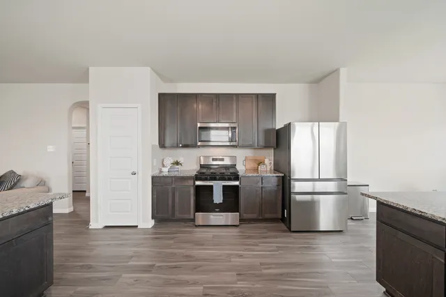 a kitchen with cabinets stainless steel appliances and wooden floor