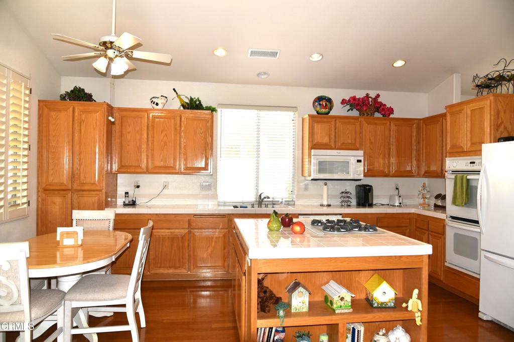 23805 Vía Compadres Murrieta, CA 92562 - Photo 4 of 13 a kitchen with a stove a refrigerator and a dining table