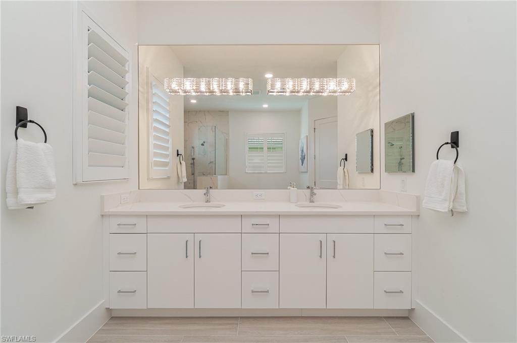 8900 Nevis Way Naples, FL 34112 - Photo 14 of 34 a bathroom with a sink and a mirror