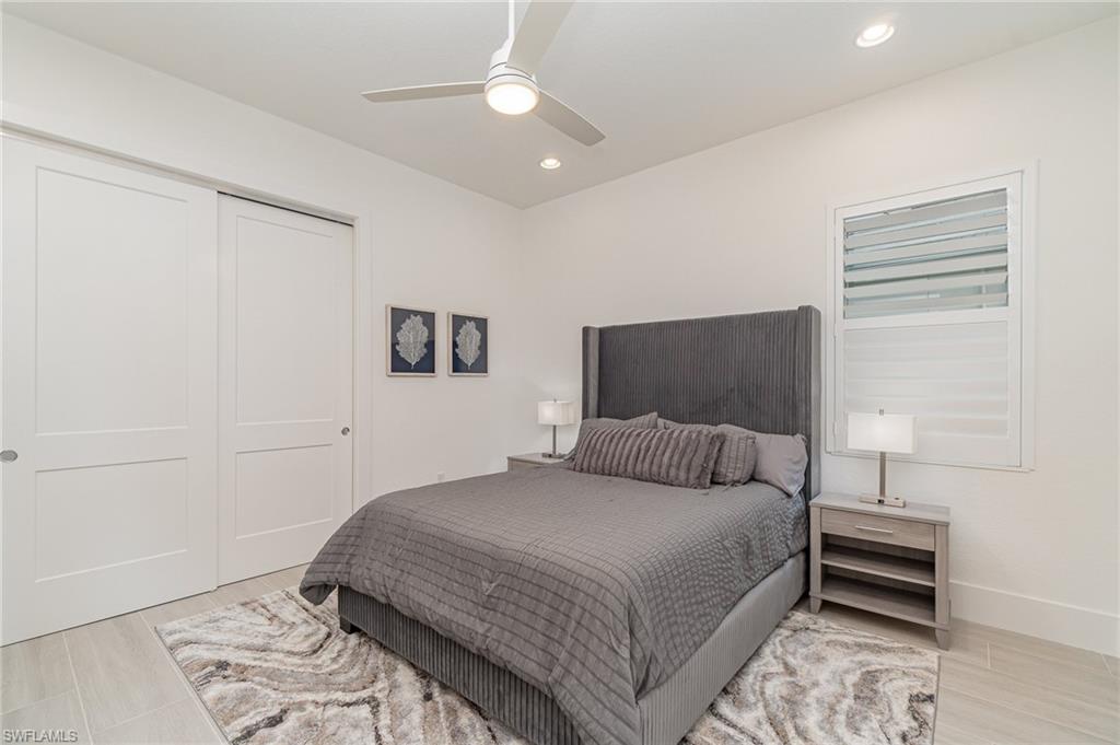 8900 Nevis Way Naples, FL 34112 - Photo 17 of 34 a bedroom with a bed and a tv