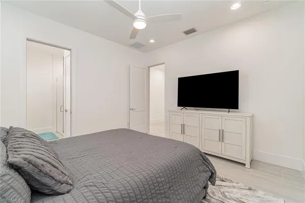 a bedroom with a bed tv and a chair