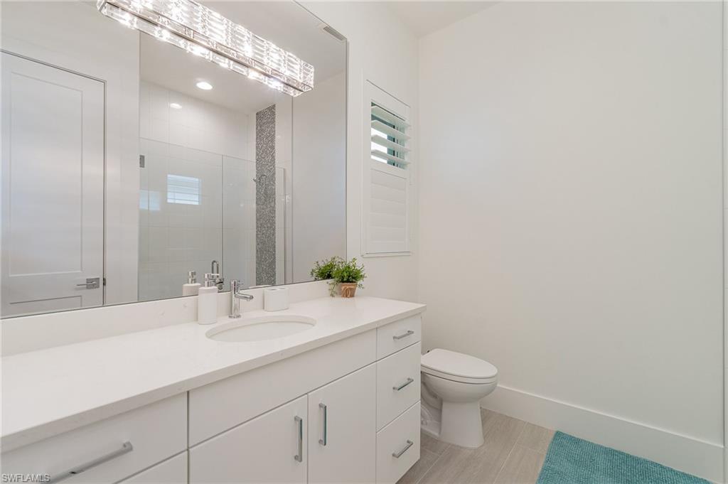 8900 Nevis Way Naples, FL 34112 - Photo 19 of 34 a bathroom with a toilet a sink and mirror