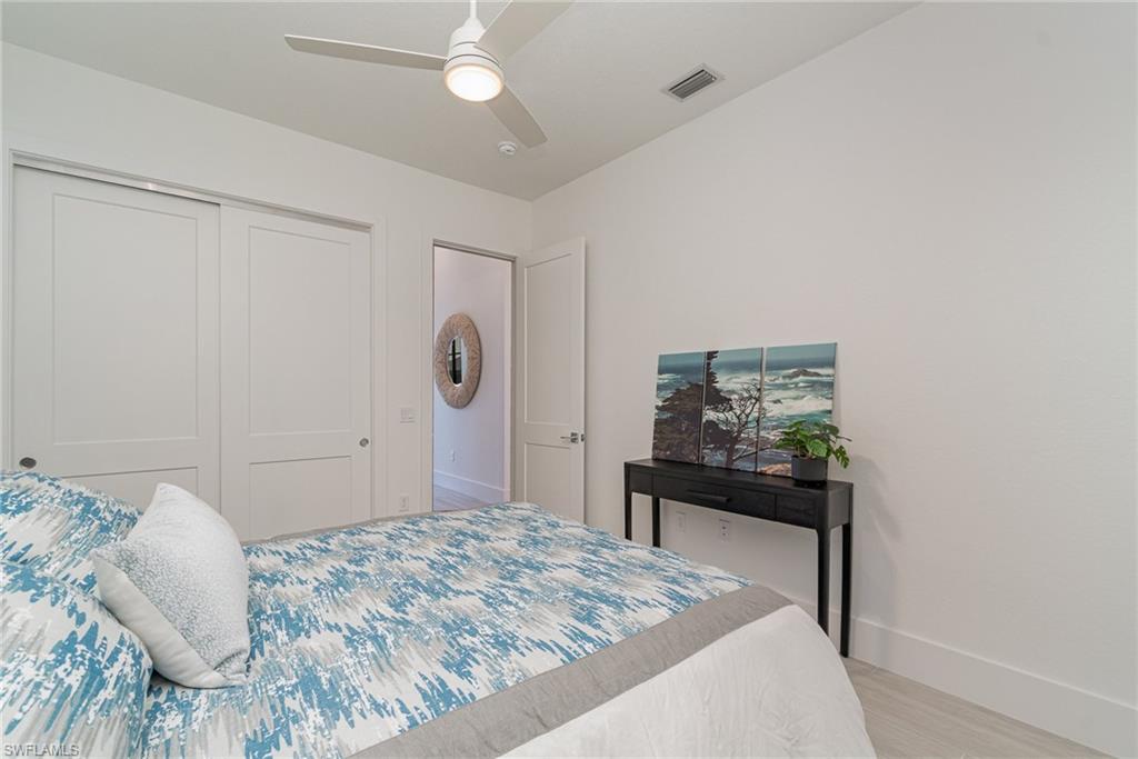 8900 Nevis Way Naples, FL 34112 - Photo 21 of 34 a bedroom with a bed and a table in it