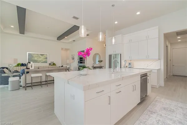 a kitchen with kitchen island granite countertop living room and white cabinets