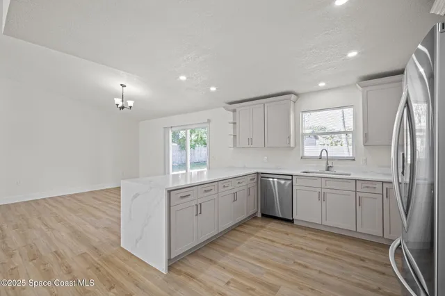 a kitchen with white cabinets appliances and sink