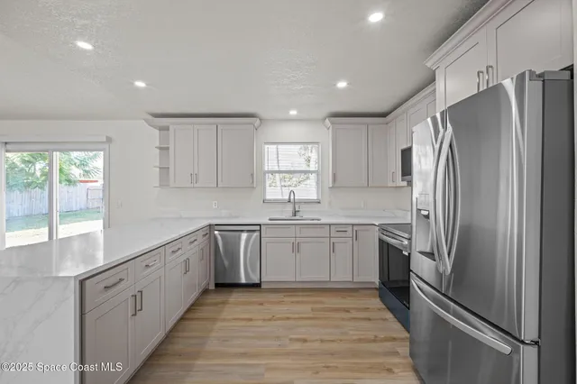 a kitchen with granite countertop stainless steel appliances cabinets a sink and a window