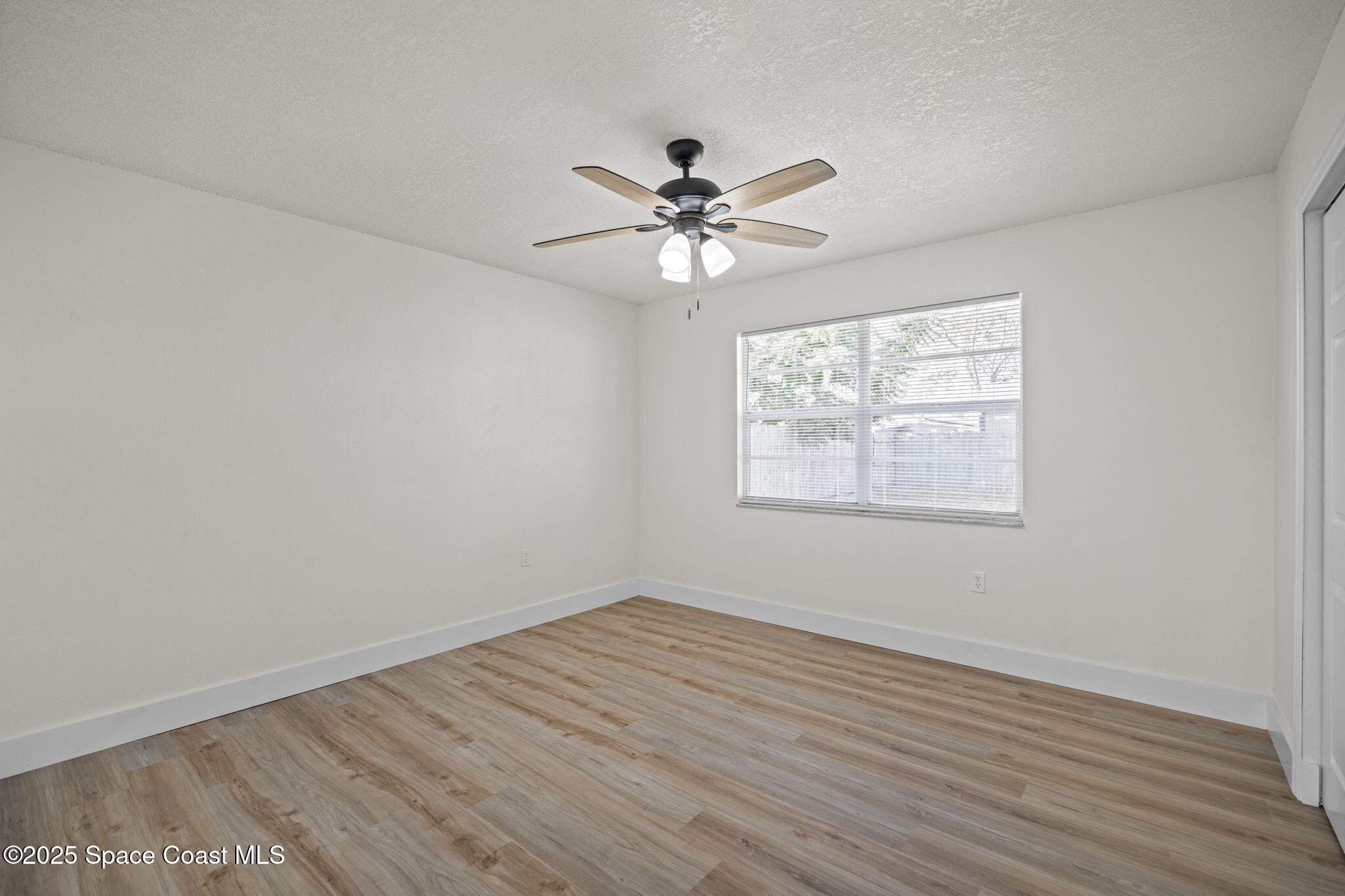 5130 Carter Street Cocoa, FL 32927 - Photo 21 of 33 an empty room with wooden floor fan and windows