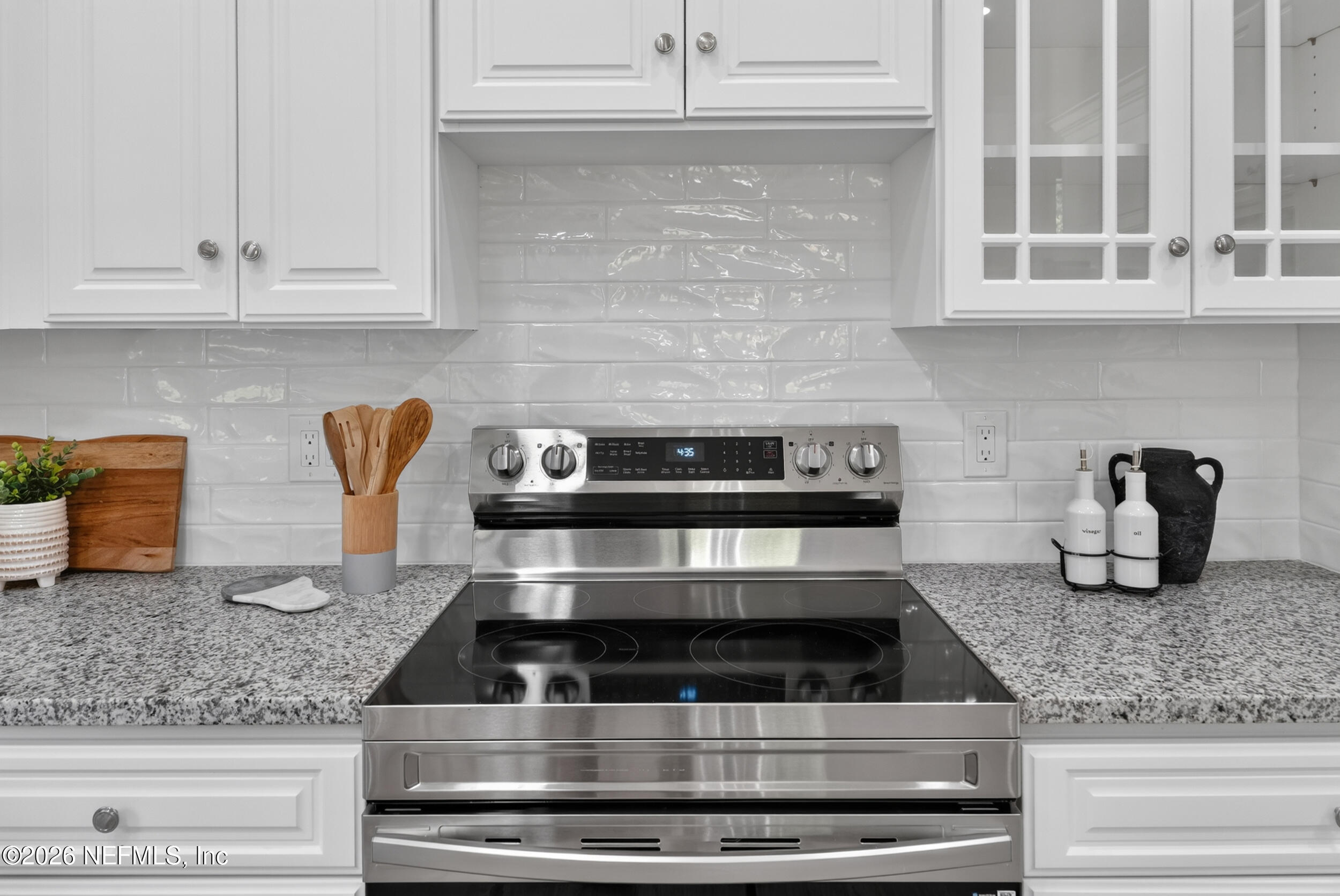 3090 Monument Bay Road St. Augustine, FL 32092 - Photo 15 of 56 a kitchen with granite countertop a stove and white cabinets