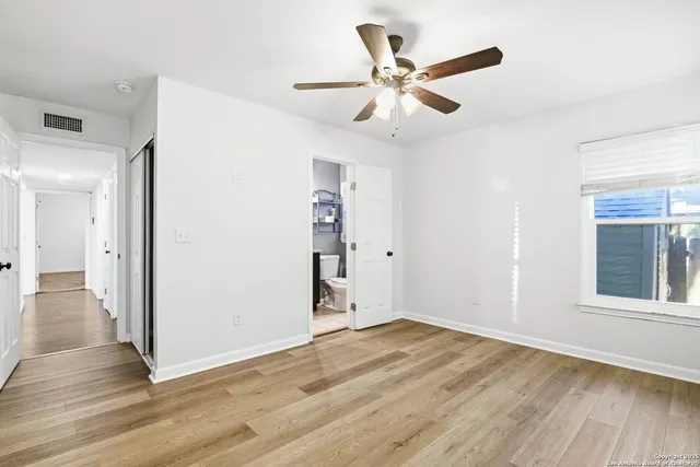 a view of a livingroom with wooden floor and a ceiling fan