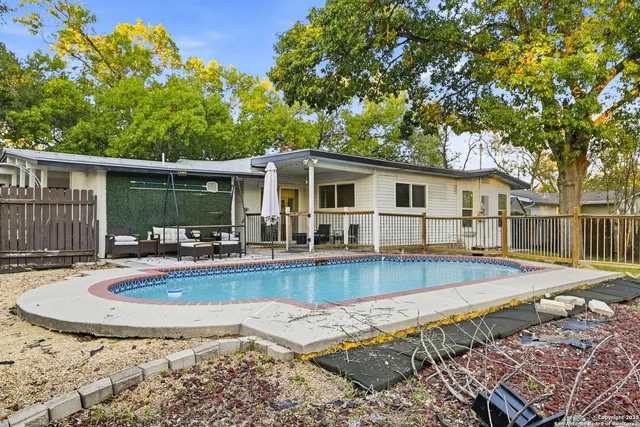a view of a house with pool and chairs