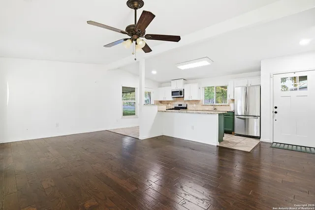 a view of a kitchen with a sink wooden floor and a window