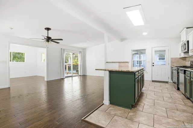 a kitchen with granite countertop a refrigerator and a stove top oven
