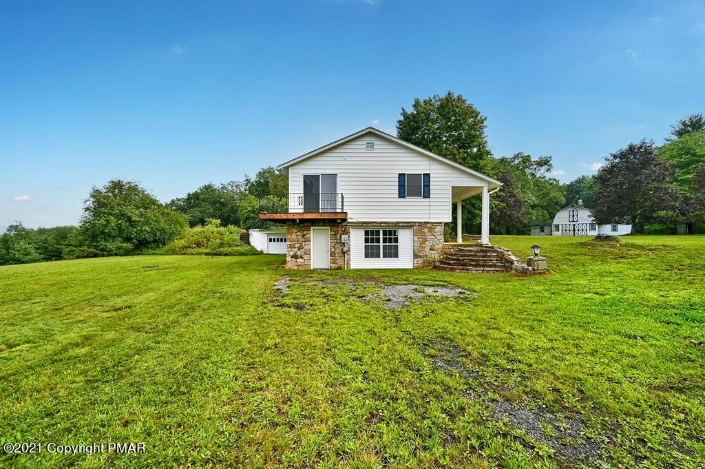 171 VanWhy Road Bushkill, PA 18324 - Photo 59 of 61 a view of a house with a big yard potted plants and large tree