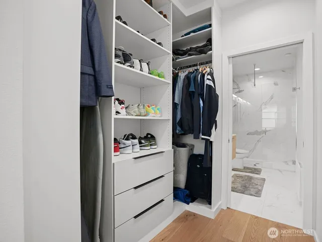 a view of walk in closet with clothes and shoes