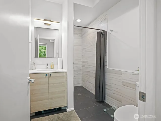 a bathroom with a shower sink and mirror