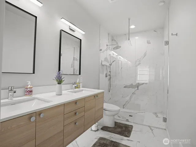 a bathroom with a double vanity sink mirror and toilet