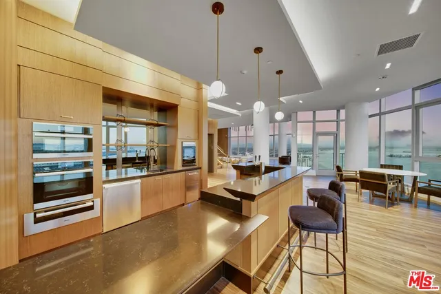 a large white kitchen with lots of counter space and chandelier