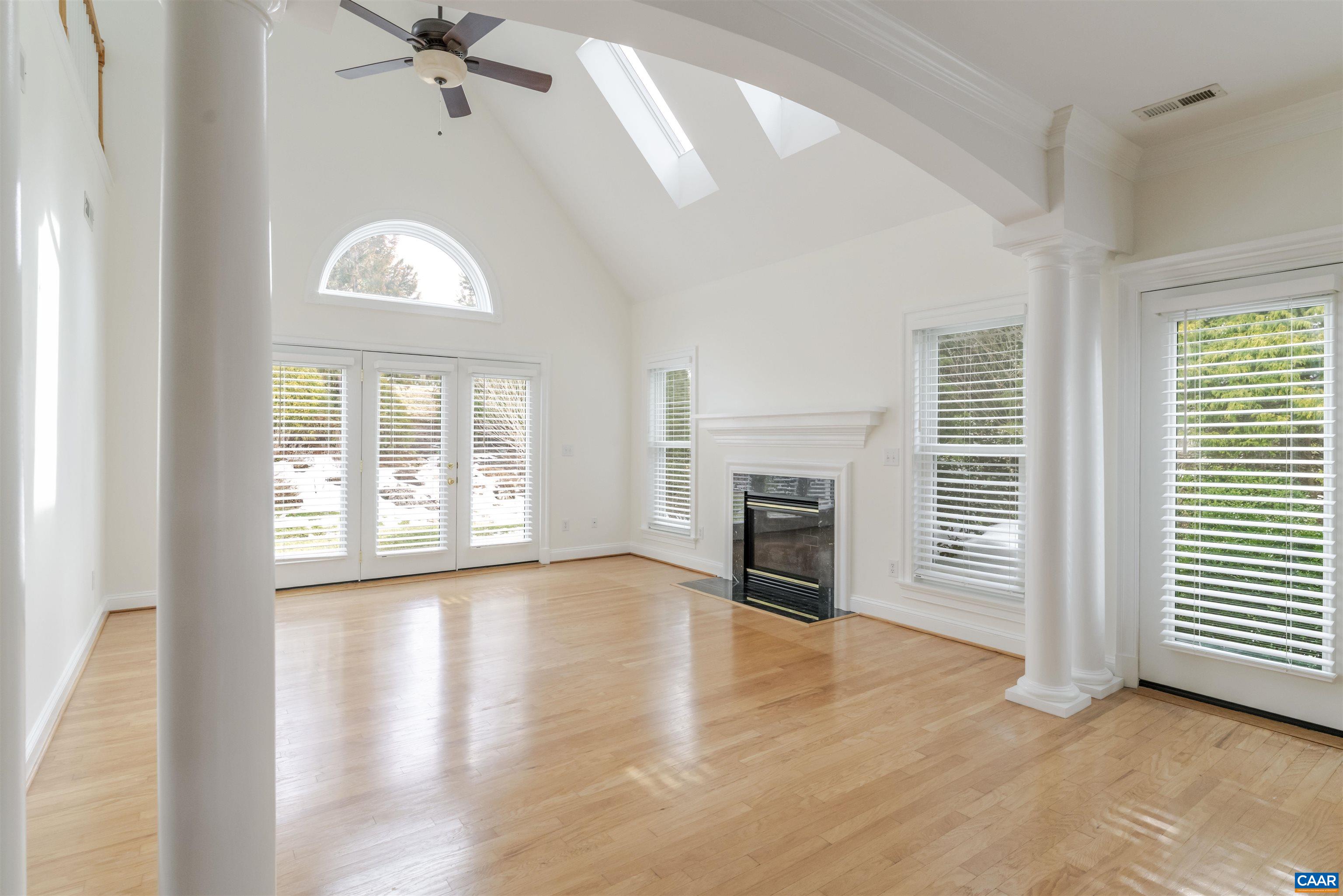 1202 Stonegate Way Crozet, VA 22932 - Photo 5 of 42 an empty room with windows fireplace and wooden floor