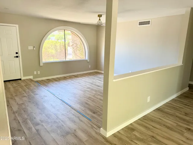 a view of an empty room with wooden floor and cabinet