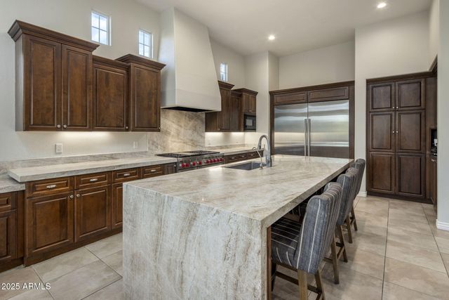 a kitchen with stainless steel appliances granite countertop a sink and a stove