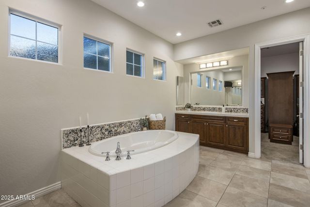 a spacious bathroom with a bathtub sink mirror and toilet