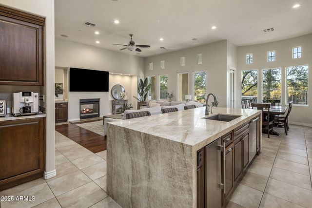 a large kitchen with kitchen island a sink and a large mirror in it