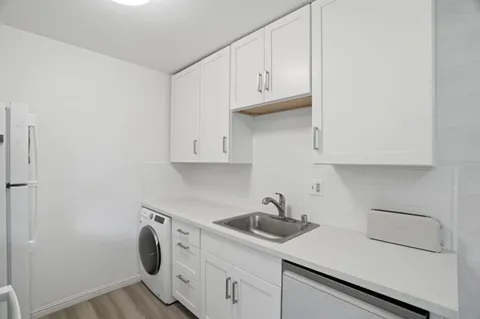 a kitchen with white cabinets and sink