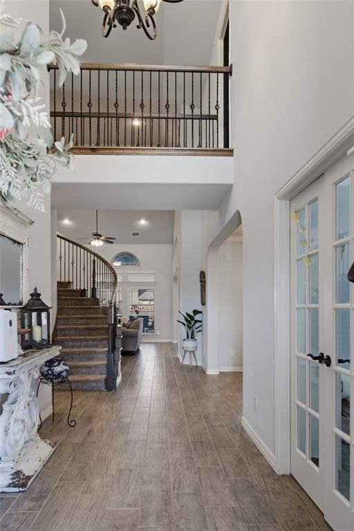 464 LeTara Ranch Drive Haslet, TX 76052 - Photo 5 of 37 Two-story foyer featuring wood-finish tile flooring, a curved staircase with wrought iron balusters, a second-story overlook, and French doors to the flex space