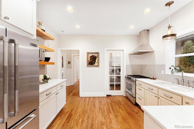 a kitchen with a sink cabinets wooden floor and stainless steel appliances