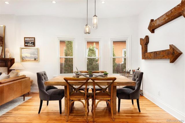 a view of a dining room with furniture a chandelier and wooden floor