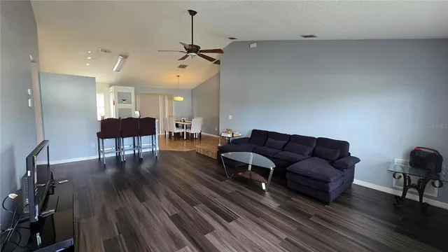 a living room with furniture and a wooden floor