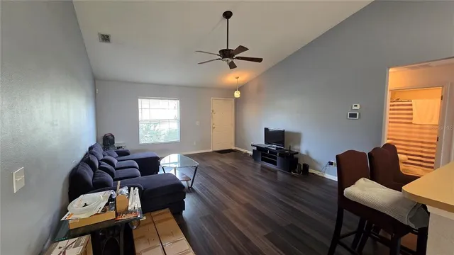 a living room with furniture two window and a flat screen tv