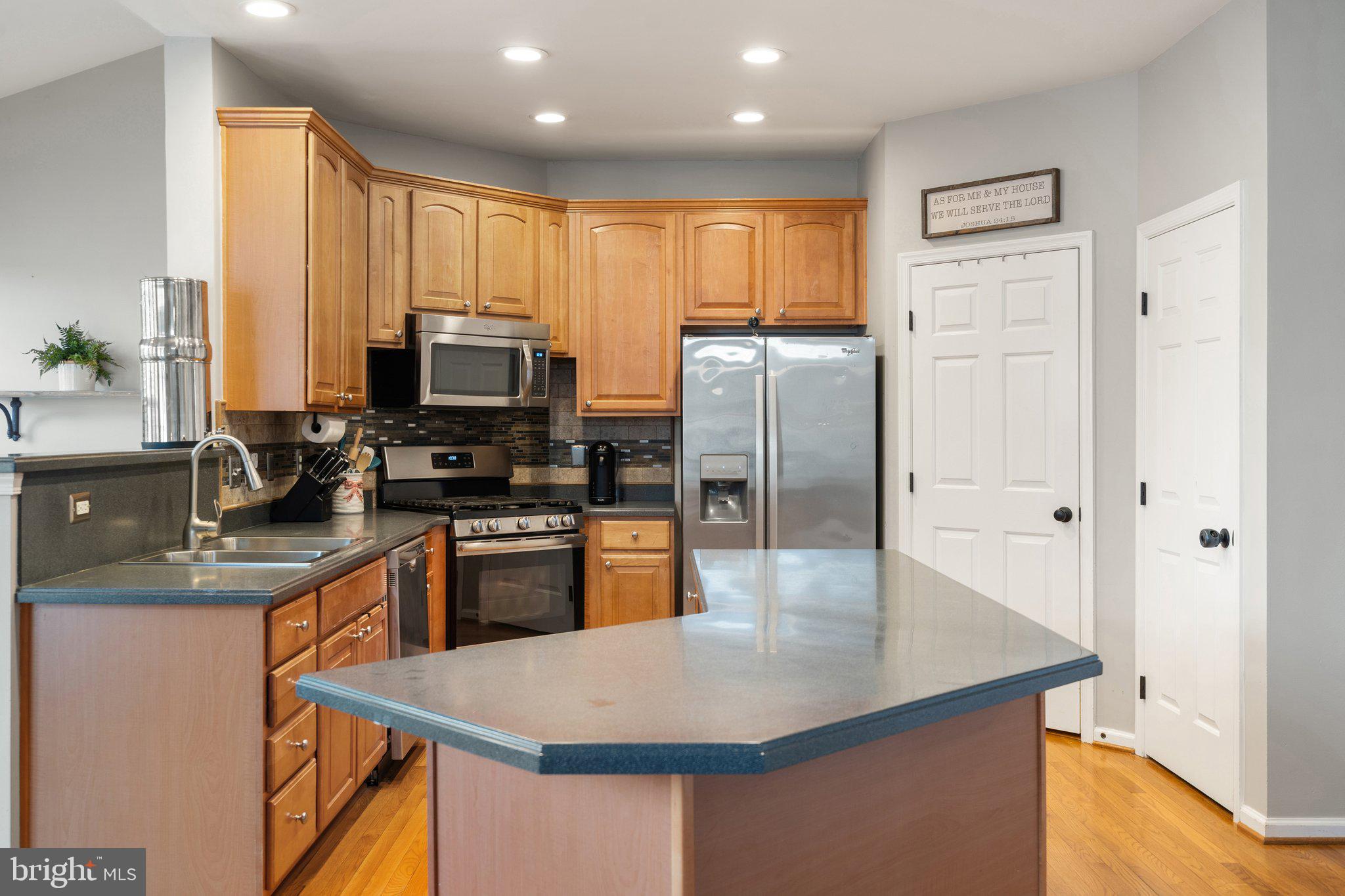6754 Stapleton Place Gainesville, VA 20155 - Photo 11 of 39 a kitchen with stainless steel appliances granite countertop a refrigerator a stove top oven a sink and dishwasher
