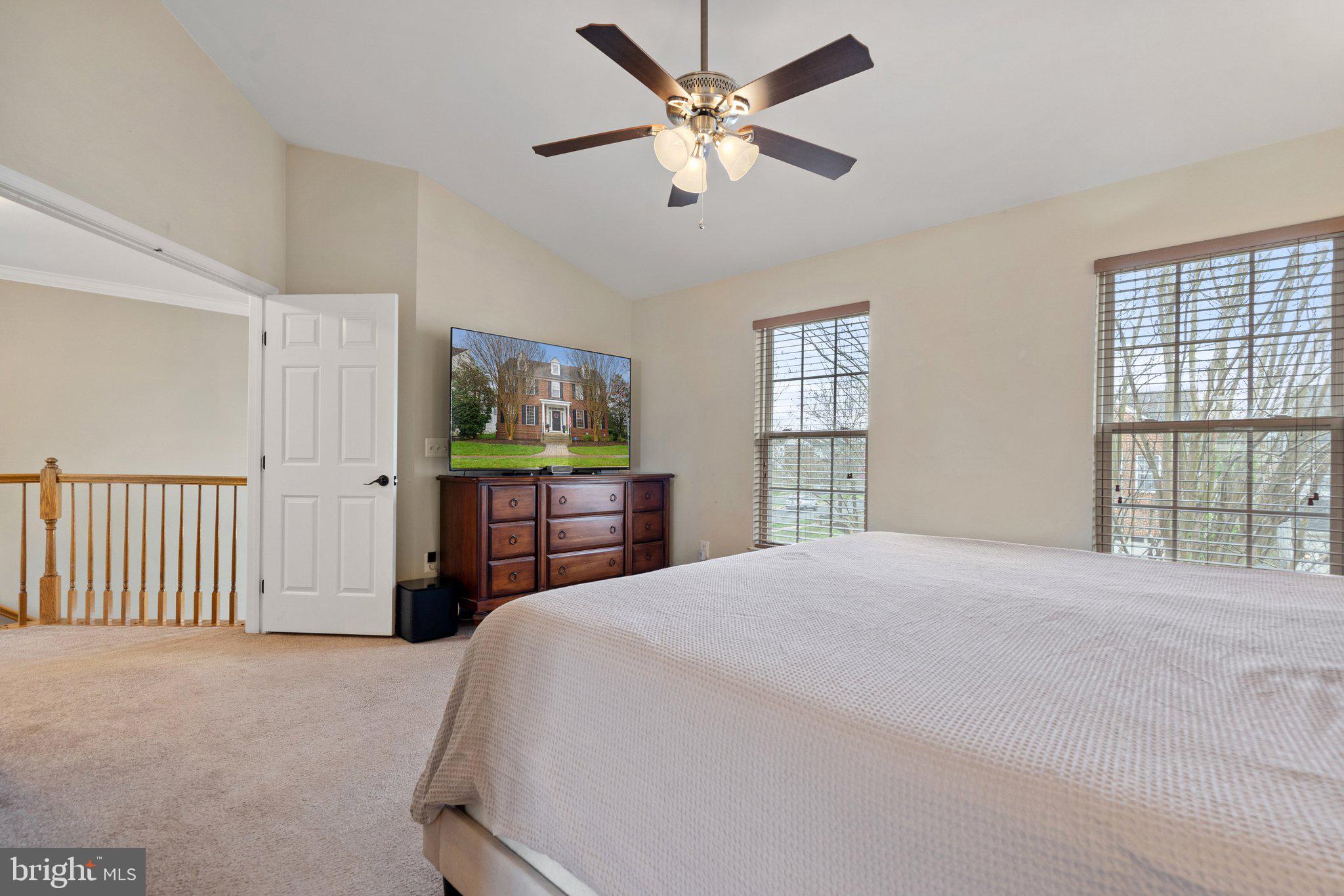 6754 Stapleton Place Gainesville, VA 20155 - Photo 19 of 39 a spacious bedroom with a bed and a large window with a chandelier